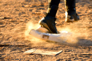 Man,Running,Across,Dusty,Baseball,Base,Blurred,Background